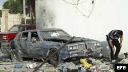 Un agente inspecciona el lugar donde un coche bomba fue detonado en la ciudad de Basora, Irak 