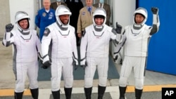Los astronautas Shannon Walker, Victor Glover, Michael Hopkins y el japonés Soichi Noguchi, listos para abordar la cápsula Dragon de la missión Crew-1 de SpaceX. 