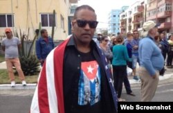 Daniel Llorente se manifiesta envuelto en una bandera estadounidense a la llegada del crucero Adonia a La Habana, en mayo de 2016.