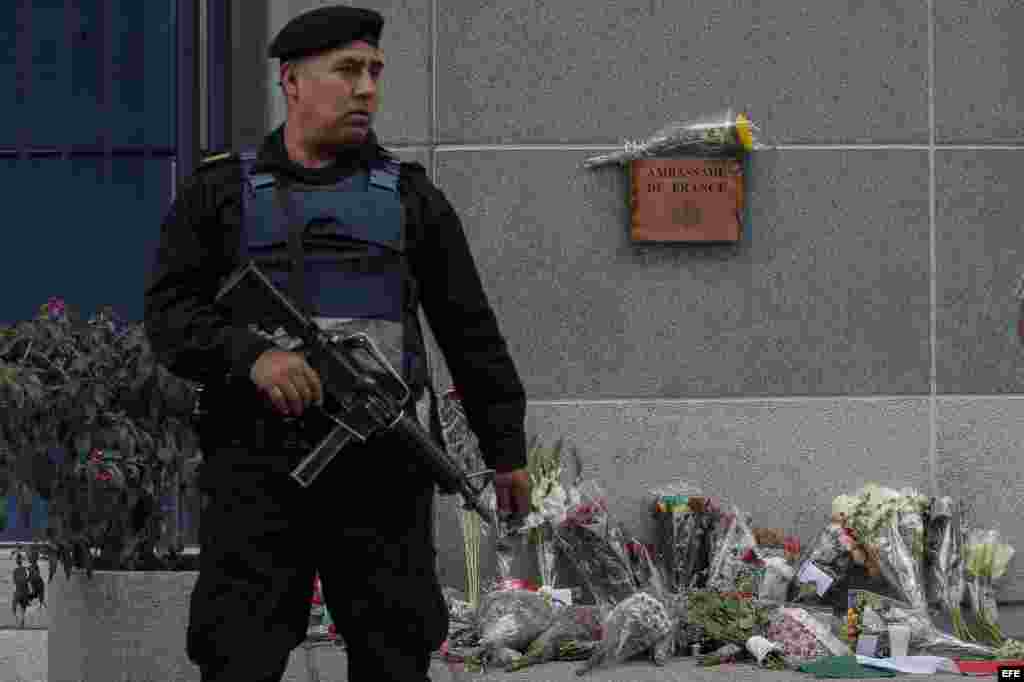 Una guardia custodia el acceso a la embajada de Francia mientras ciudadanos colocan flores en el lugar, en la capital mexicana. EFE