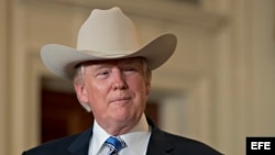 El presidente Donald Trump se prueba un sombrero de vaquero Stetson, mientras participa en la presentación de productos "Made in America" en la Casa Blanca, en Washington (Estados Unidos).