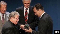 El ministro polaco de Exteriores Radoslaw Sikorski (3-d) felicita al padre José Conrado (2-i), quien recibió el premio Geremek, durante el encuentro de la Comunidad de Democracias en Cracovia, Polonia, el sábado 3 de julio de 2010.