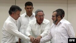 Juan Manuel Santos estrecha la mano del líder de las FARC, Rodrigo Londoño, alias "Timochenko", tras la firma del acuerdo.