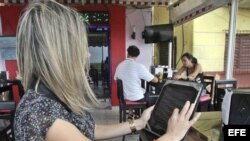 Una joven observa el menú en una tableta en un restaurante de La Habana. 