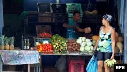 Un hombre le vende productos del campo a una mujer en Santiago de Cuba.
