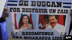 En la imagen tomada en abril de 2018 un manifestante sostiene un cartel contra Ortega y Murillo.