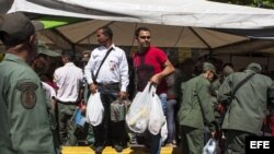 Un grupo de personas hace compras en un punto al aire libre de venta de comida regulada por el Gobierno venezolano, en Caracas (24 de enero, 2015).