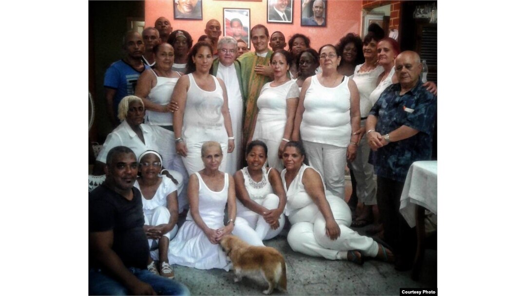Damas de blanco y opositores se toman una foto con los padres José Conrado y Castor Álvarez luego de terminar la misa en la sede nacional de las Damas de Blanco. (Cortesía Angel Moya).