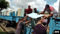 Varios hombres suben un viejo refrigerador a un camión. Centenares de frigoríficos soviéticos y americanos fueron recogidos para ser cambiados por económicos aparatos chinos que el Gobierno vendió a los cubanos. 