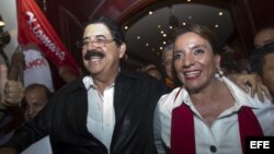 La candidata presidencial hondureña por el partido Libertad y Refundacion (LIBRE), Xiomara Castro (d), y su esposa y expresidente Manuel Zelaya (i), derrocado en 2009, sonríen hoy, domingo 24 de noviembre de 2013, durante un evento en el que declararon a 