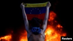 Un manifestante sostiene la bandera venezolana durante una protesta en Caracas. (REUTERS/Carlos Garcia Rawlins/Archivo)