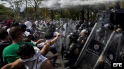Manifestantes se enfrentan con integrantes de la Policía Nacional Bolivariana durante una protesta en la Universidad Central de Venezuela.