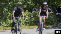 El presidente de Estados Unidos, Barack Obama, y su hija, Malia (d), montan en bicicleta en el Correllus State Bike Path en la isla de Martha's Vineyard, Massachusetts, Estados Unidos.