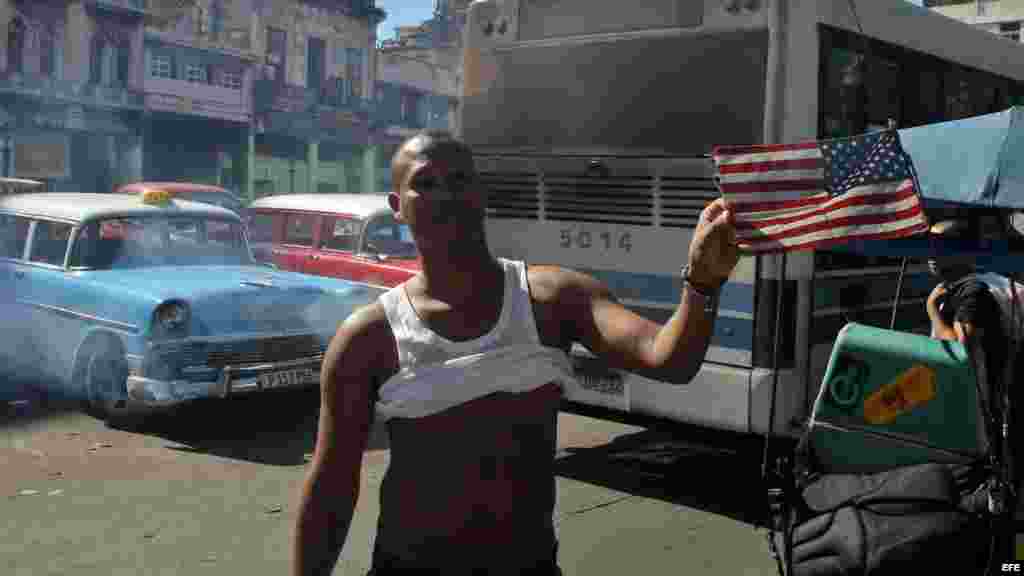 Orgulloso, un habanero joven muestra la bandera de Estados Unidos que tiene en su bicitaxi hoy. Como si tiempo atrás no hubiera sido motivo de escarnio público.