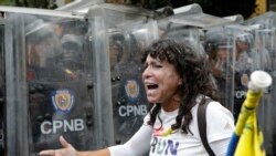 Una opositora se manifiesta ante la línea de miembros de la policía venezolana que impidió el paso de una marcha de la oposición en Caracas, Venezuela, el 10 de marzo del 2020.