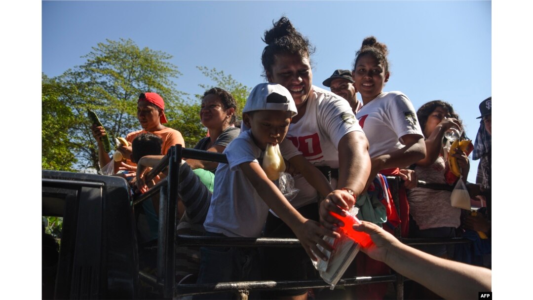 Migrantes hondureños reciben comida en Acacoyagua, Chiapas, México.