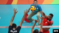 El cubano Osniel Melgarejo (d) golpea el balón ante los iraníes Seyed Mohammad Mousavi Eraghi (i) y Mir Saeid Marouflakrani (c) el 11 de agosto de 2016, durante el partido de voleibol que disputaron ambos equipos en los Juegos Olímpicos Río 2016. 