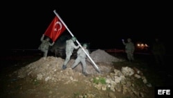 Soldados izan la bandera turca en la tumba de Suleimán. 