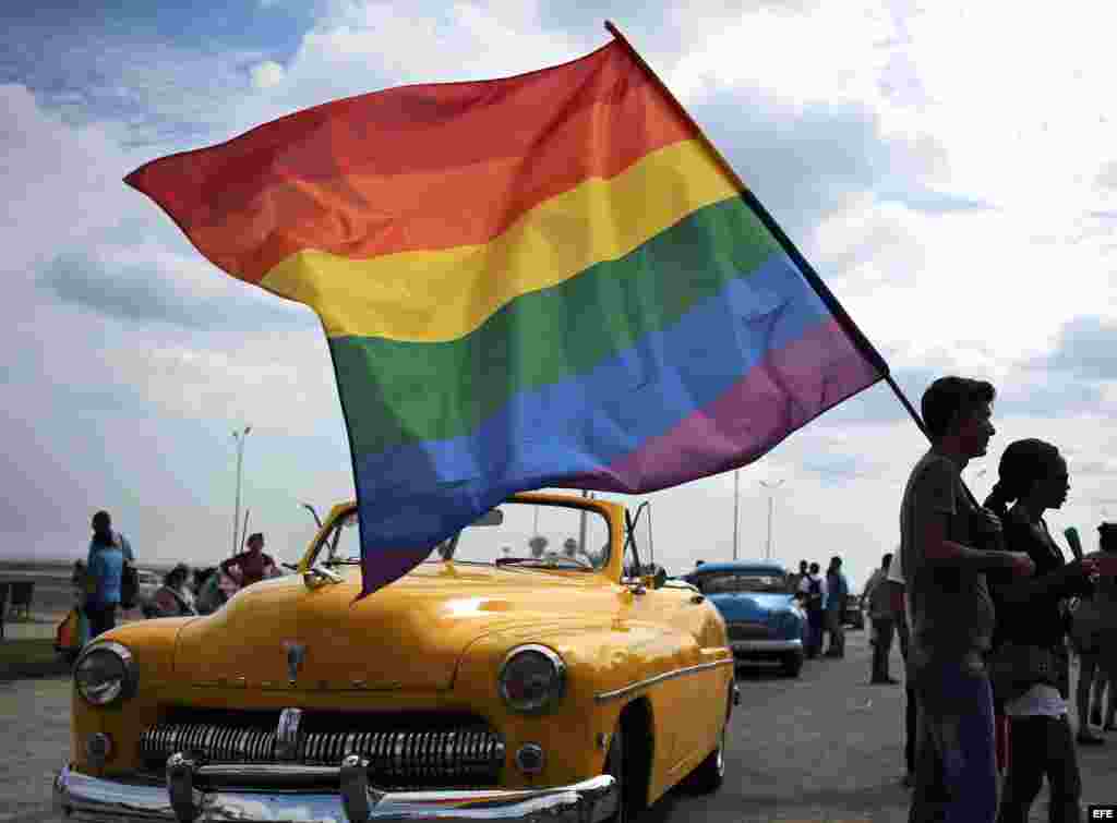 Un grupo de personas sostiene una bandera de la comunidad LGTBI durante una "conga" contra la homofobia y la transfobia en La Habana.