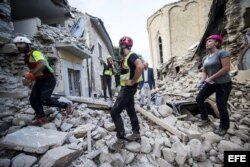 Varios voluntarios trabajan en las labores de rescate tras el terremoto en la localidad de Amatrice, en el centro de Italia.