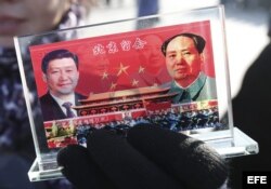 Un vendedor expone un recuerdo con la imagen del presidente chino, Xi Jinping (izq), y del fallecido líder Mao Zedong (dcha) en la Plaza de Tiananmen, en Pekín (China).