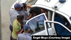 Berta Soler, vocera del movimiento opositor Damas de Blanco en La Habana, es introducida a un auto patrullero por fuerzas policiales.