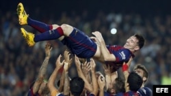 Messi es lanzado al aire por sus compañeros de equipo.