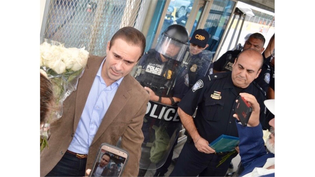 Polo sostiene el ramo de rosas blancas que le entregaron los cubanos en Reynosa.