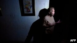Una mujer habla en su casa ubicada en Maracaibo durante un corte de luz . 