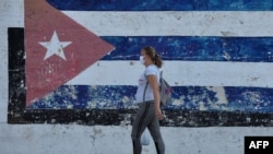 Una mujer usa una máscara protectora contra el coronavirus en una calle de La Habana. (YAMIL LAGE/AFP)