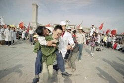 Un socorrista ayuda a un estudiante desmayado en su tercer día del huelga de hambre en la Plaza de Tiananmen, China el 16 de mayo de 1989. AP Photo/Sadayuki Mikami, File