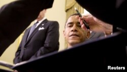 El presidente Obama a punto de firmar una orden. 
