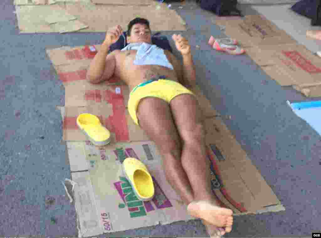 Uno de los jóvenes cubanos varados en Costa Rica descansa a las afueras de las oficinas de Migración.