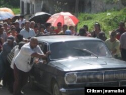 Dolientes empujando un carro fúnebre en Cabañas, Artemisa. Foto: Moisés L. Rodríguez.