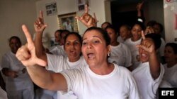 Damas de Blanco vitorean a su fallecida líder, Laura Pollán, hoy lunes 24 de septiembre de 2012, en su sede en La Habana (Cuba), mientras un grupo de personas afines al Gobierno cubano las mantiene rodeadas y les impide asistir a la iglesia para celebrar 