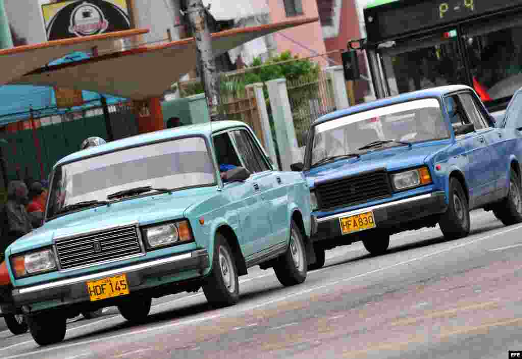  Dos vehículos particulares de fabricación rusa circulan las calles de La Habana, Cuba. 