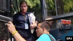 Agente de Migración de Costa Rica entrega visa a cubanos varados en ese país.
