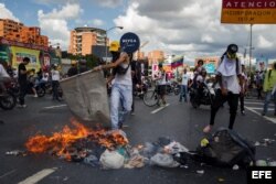 Un grupo de personas se enfrenta a miembros de la Policía Nacional Bolivariana al finalizar la "Toma de Caracas".
