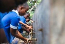 Alumnos de una escuela de Blantyre (Malaui) se lavan las manos en una instalación proporcionada por “Water for People”. (© Water for People)