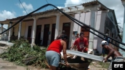 Ciudadanos cargan tejas para refaccionar el techo de sus casas en el pueblo de Los Palacios, provincia de Pinar del Río (Cuba).