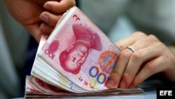 Empleado de banca cuenta billetes en la localidad de Suining, en la provincia china de Sichuan, China. 