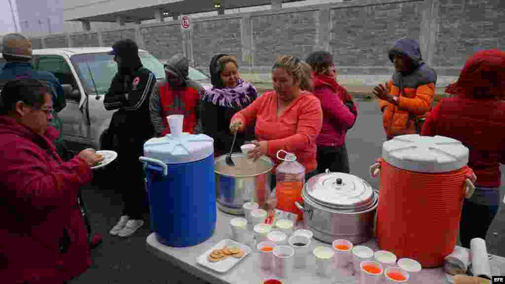 n grupo de ciudadanos cubanos reciben alimentos en la línea fronteriza de Nuevo Laredo (México) con territorio estadounidense este lunes 30 de enero de 2017. Decenas de cubanos se reúnen todos los días frente al Puente Internacional Las Américas de la fro