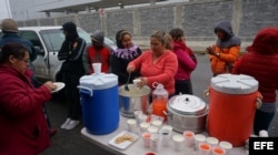 Un grupo de ciudadanos cubanos reciben alimentos en la línea fronteriza de Nuevo Laredo.