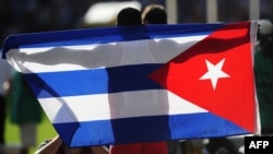 Un deportista cubano celebra su triunfo con la bandera de Cuba.