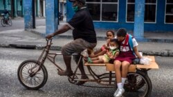 Un hombre transporta niños en su triciclo, en La Habana, en medio de la nueva pandemia de coronavirus. (Foto AP / Ramón Espinosa)