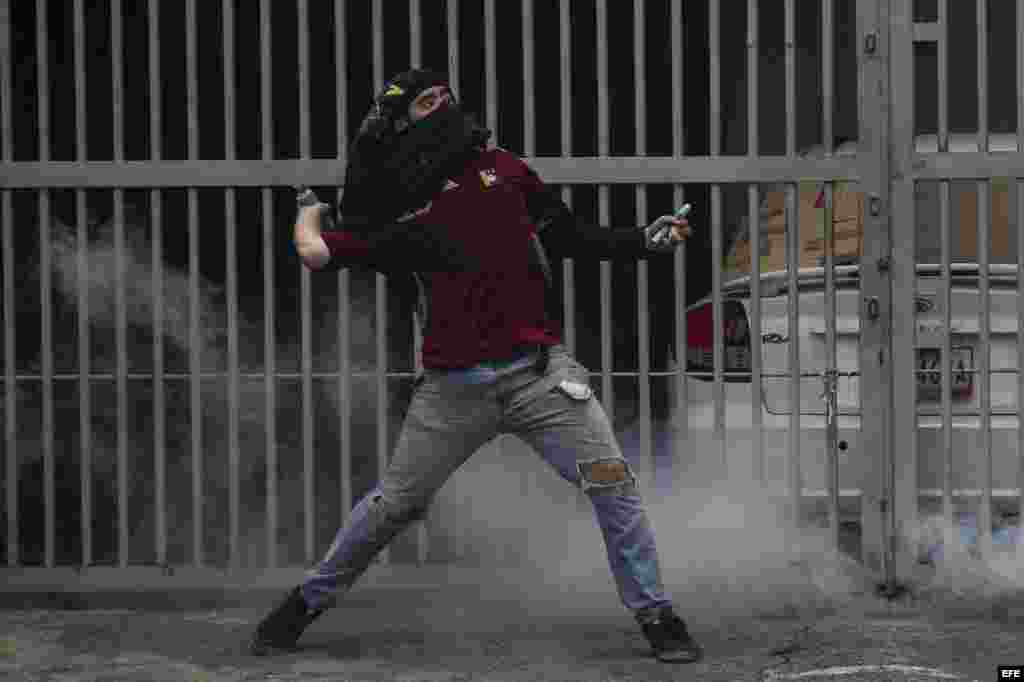 Una imagen común, un manifestante se enfrentan con agentes de la Policía Nacional Bolivariana (PNB) en Caracas (Venezuela).