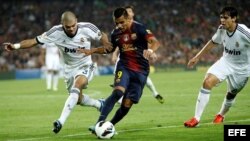 El delantero chileno del Barcelona Alexis Sánchez (c) es presionado por el defensa portugués Képler Lima "Pepe" (i) y el centrocampista brasileño Ricardo Izecson "Kaká" (d), ambos del Real Madrid.