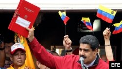El presidente de Venezuela, Nicolás Maduro (c), muestra el decreto con la propuesta de constituyentes durante un acto oficial.