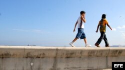 Dos niños caminan por el malecón de La Habana. 