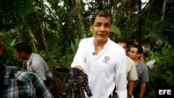 Foto de archivo del expresidente Rafael Correa con la mano manchada de crudo de un reservorio antiguo de desechos petroleros en la Amazonía. 